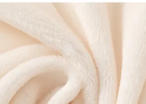 Detail of soft cream-colored faux fur fabric texture for girls' winter jacket