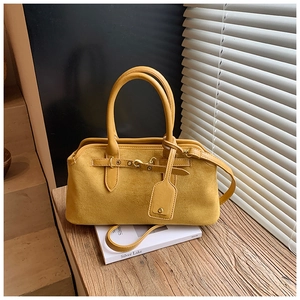 Vue détaillée du sac en daim jaune avec rivets en bronze et finitions métalliques