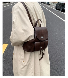 Detailansicht eines dunkelbraunen Vintage-Rucksacks mit Lederstruktur und Silberverschluss