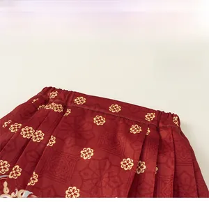Detail of red Hanfu skirt with golden daisy patterns and elastic waistband texture