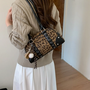 Detail of leopard print boston bag with silver eyelets, rivets and baseball charm