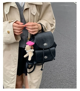Detail eines schwarzen Vintage-Lederrucksacks mit Drehverschluss und Hund-Anhänger