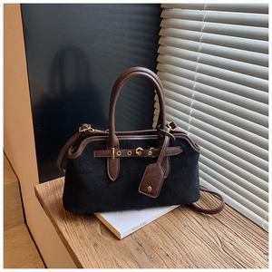 Détail de la texture noire mate et des lanières en cuir marron sur le sac vintage