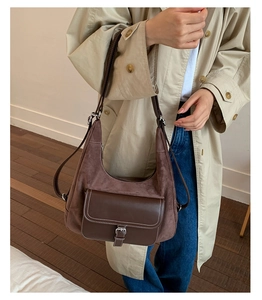 Detail of vintage brown hobo bag showing matte texture, contrast stitching, and buckle