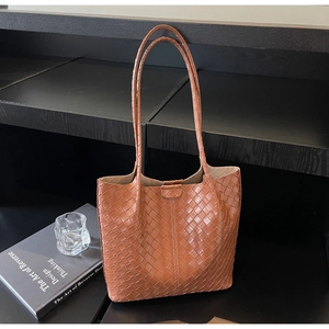 Close-up of the deep brown woven leather texture and intricate intrecciato pattern details