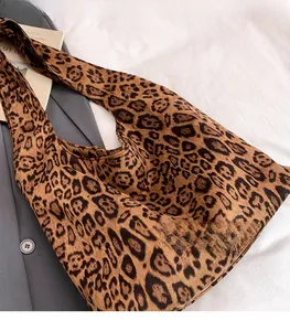 Detail of leopard print tote bag fabric showing soft texture on a grey blazer background