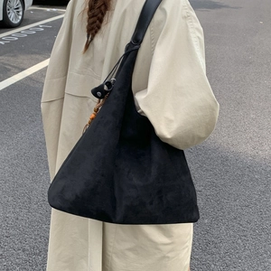 Dettaglio di una grande borsa hobo in camoscio nero con trama opaca e design morbido