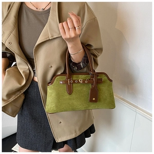 Détail du sac à main en daim vert et cuir marron avec fermoir doré et design rétro