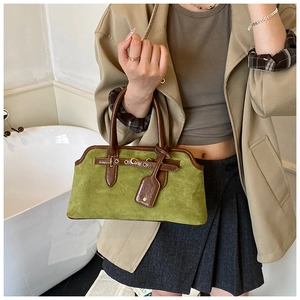Détail du sac à main rétro en daim vert avec bordure en cuir marron et boucles en métal
