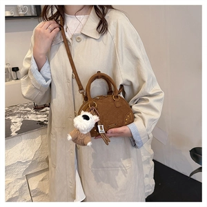 Brown faux suede Boston bag detail with gold rivets and cute puppy charm accessory