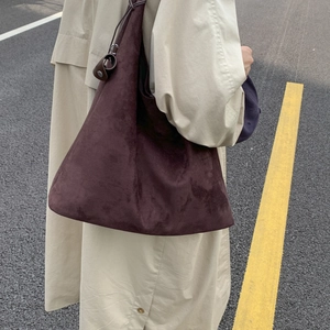 Borsa tote in camoscio marrone abbinata a un trench beige per un look autunnale sobrio