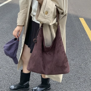 Grande borsa tote in pelle scamosciata marrone scuro indossata con un elegante trench beige