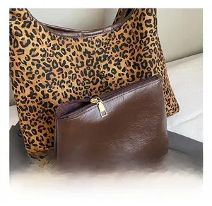Nahaufnahme der Leopard-Tragetasche mit brauner Ledertasche und goldener Hardware