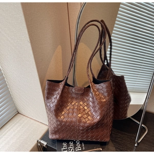 Detailed view of brown leather woven tote bag showing Intrecciato craft and soft texture