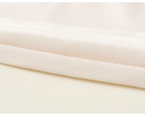 Close-up detail of soft cream flannel fabric texture on children festive winter cloak