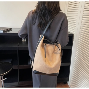 Détail du sac seau kaki montrant la fermeture à cordon et les finitions en cuir noir
