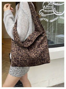 Detailed view of leopard print tote bag with wide strap on shoulder for daily commute
