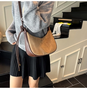 Close-up of brown suede hobo bag with unique knotted leather strap detail
