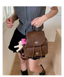 Detailansicht brauner Vintage-Lederrucksack mit silbernen Drehverschlüssen und Plüschanhänger