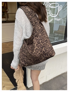 Detailed view of the large capacity leopard print tote bag styled with a grey knit outfit