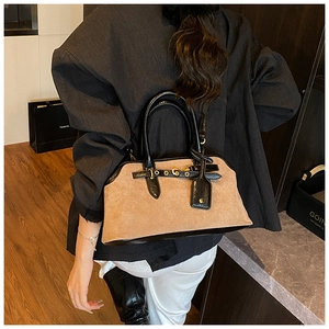 Photo professionnelle d'un sac à main en daim kaki avec garniture en cuir noir sur modèle