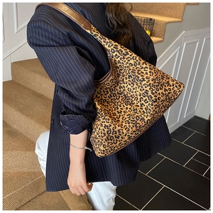 Detailansicht der Leoparden-Einkaufstasche mit Lederriemen an einem Model in einem Blazer