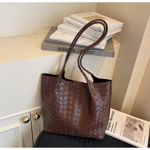 Detail shot of deep brown woven texture on a large synthetic leather tote bag