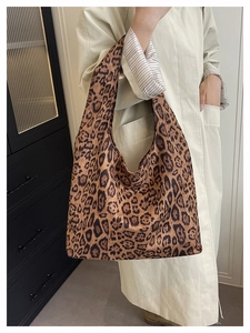 Fashionable leopard print tote bag shown in a side-carry style with a beige trench coat