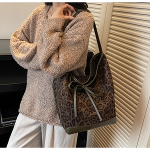 Détail du sac cabas léopard avec bordures en cuir vert olive et petit nœud décoratif