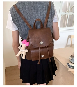 Nahaufnahme des braunen Vintage-Rucksacks mit Hundeanhänger und Metall-Drehverschluss