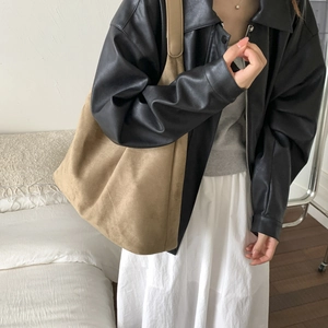 Dettaglio della borsa tote in pelle scamosciata color cammello e giacca