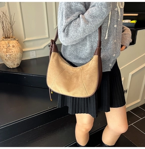 Detailed view of khaki suede hobo bag with dark brown leather strap and knot detail