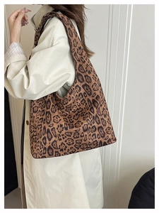 Detailed view of the leopard print hobo tote bag on model for casual commuting style
