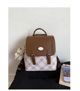 Detail of vintage flap backpack featuring brown leather contrast and pink checkered fabric