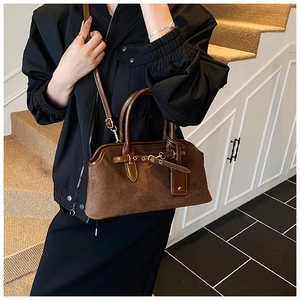 Détail d'un sac à main vintage en cuir givré marron avec boucle en métal et anse lisse