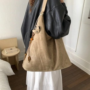 Grande borsa hobo moderna in camoscio kaki indossata sulla spalla in stile minimal