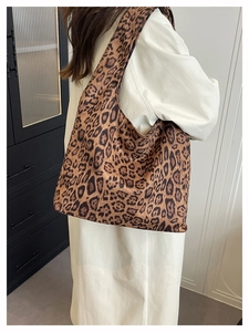 Detail view of large leopard print tote bag worn by model showing casual drape and style