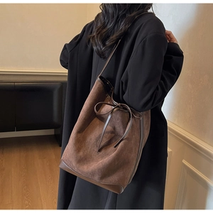 Détail du sac cabas vintage en suédine marron avec nœud en cuir et coins renforcés