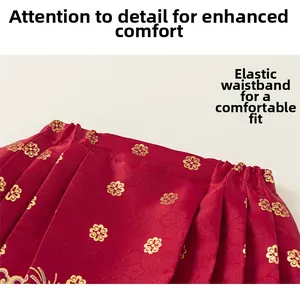 Detailed view of red and gold floral brocade fabric with comfortable elastic waistband