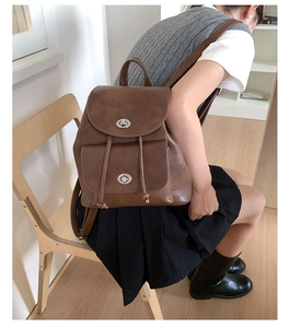 Nahaufnahme des braunen Vintage Lederrucksacks mit silbernem Drehschloss und Kordelzug