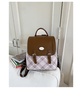 Detail of a pink plaid college style backpack with brown leather straps and bunny badge