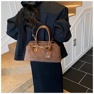 Détails du sac vintage en daim marron avec lanières en cuir et boucles dorées élégantes