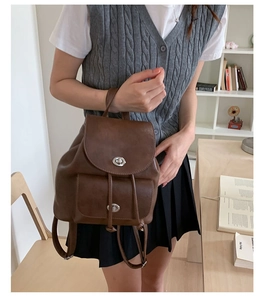 Detail eines dunkelbraunen Vintage-Lederrucksacks mit silbernen Metalldrehverschlüssen