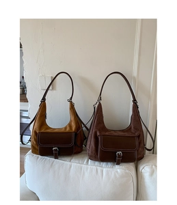 Detail showing retro hobo bags in caramel and dark coffee colors on a white sofa