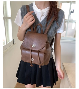Detailansicht eines braunen Vintage-Lederrucksacks mit Metall-Drehverschlüssen