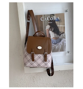 Detail of vintage pink plaid backpack showing brown leather flap and cute rabbit emblem