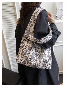 Detail view of large canvas tote bag with black paisley pattern on beige background
