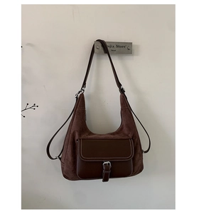 Detailed close-up of retro brown frosted suede and leather stitching on hobo bag