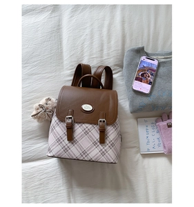 Detail of vintage backpack with plaid pattern, Cinnamoroll buckle, and plush charm pendant