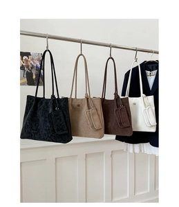 Close-up of minimalist suede tote bags with matching coin purses and embossed logo